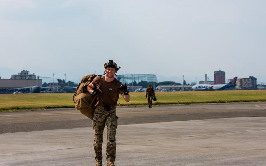U.S. Air Force Staff Sgt. Jordan Duff, 31st Rescue Squadron pararescuemen, walks away from the drop zone after landing on the ground.
